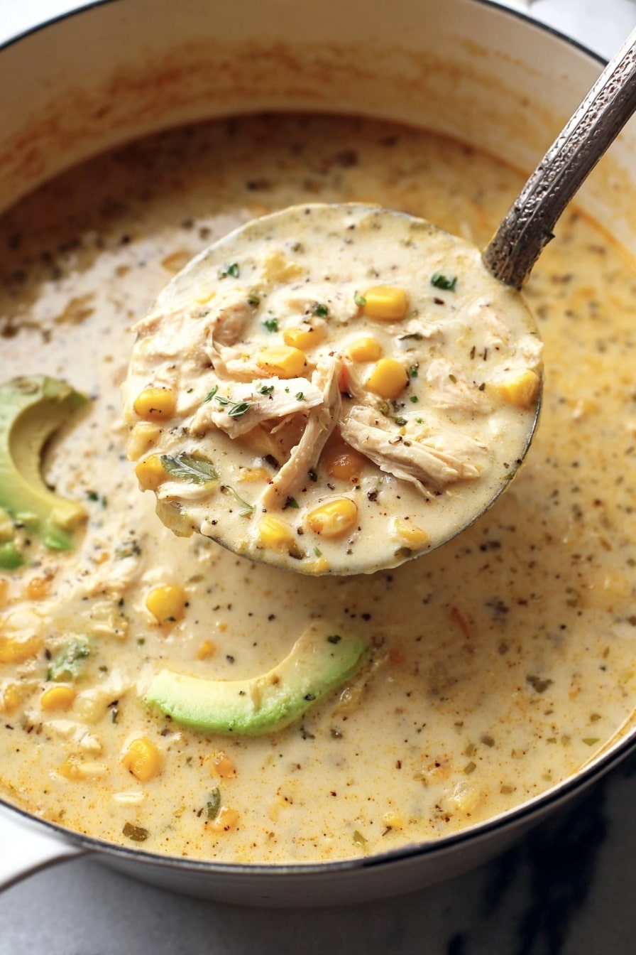 A large ladle filled with thick creamy soup is being lifted from a white pot, showing three main layers: light creamy broth with specks of black pepper and chopped herbs, soft yellow corn kernels scattered throughout, and shredded white meat pieces visible near the surface. In the background, sliced green avocado adds a fresh color contrast. The soup’s texture looks rich and smooth with some visible small chunks. The pot sits on a white marbled surface. Photo taken with an iphone --ar 2:3 --v 7