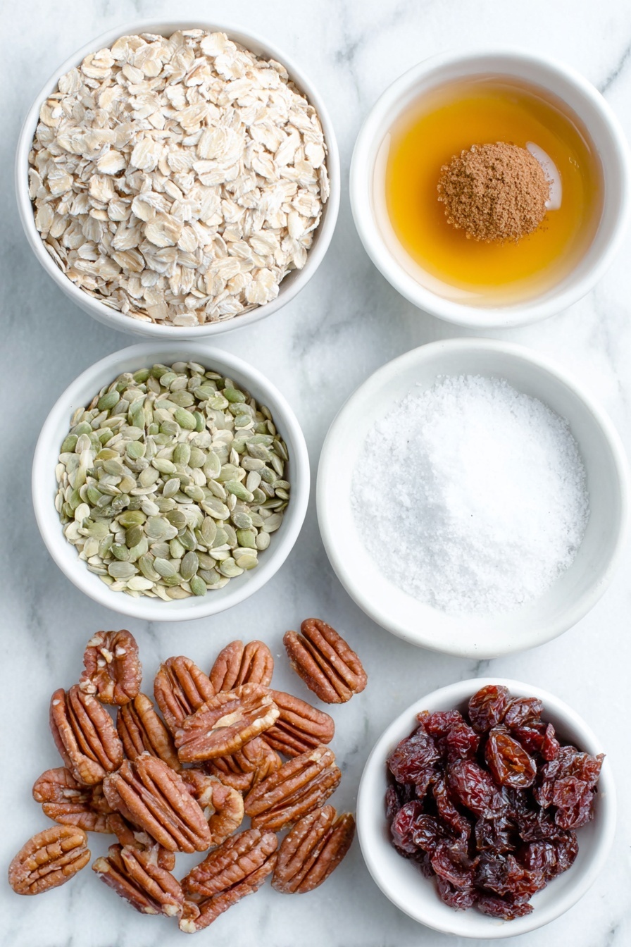 Flat lay of a small pile of old-fashioned rolled oats, a small heap of pecans, a small heap of pepitas, a small white bowl of fine-grain sea salt, a small white bowl of ground cinnamon, a small white bowl with melted coconut oil, a small white bowl with amber maple syrup, a small white bowl with clear vanilla extract, and a small mound of dried cranberries placed on a clean white marble surface, soft natural light, photo taken with an iPhone, professional food photography style, fresh ingredients, white ceramic bowls, no bottles, no duplicates, no utensils, no packaging --ar 2:3 --v 7 --p m7354615311229779997